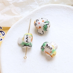 Macro shot of handcrafted Daruma ceramic beads with gold pin for DIY jewelry making