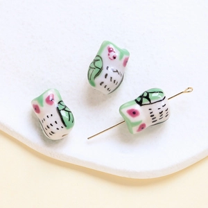 Detailed macro view of ceramic owl beads with top-to-bottom holes for DIY jewelry making