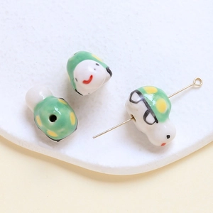 Macro view of cute green insect ceramic beads with yellow dots for DIY jewelry
