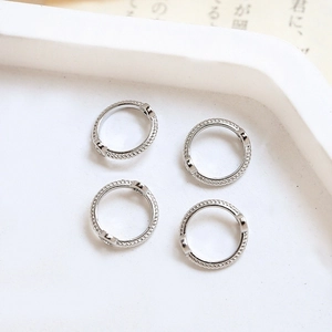 Close-up of four silver lace rings with twisted metal texture and zircon inlay