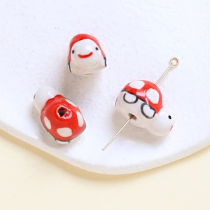 Macro shot of red mushroom ceramic beads with cute emoji faces for DIY jewelry making