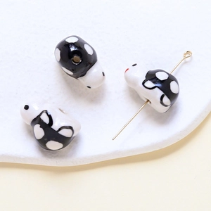 Detailed view of panda ceramic beads with polished glaze and central holes for DIY