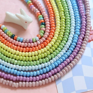 Close-up of pastel macaron ceramic beads in a U-shape layout for DIY jewelry making