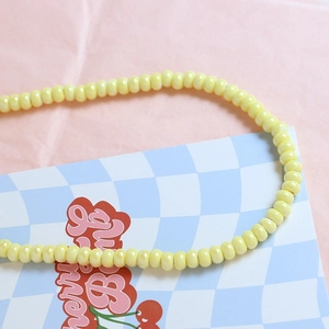Close-up of pastel yellow macaron ceramic beads for DIY jewelry and necklace crafting