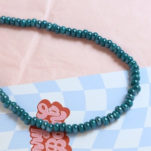 Macro detail of teal ceramic beads with iridescent finish for DIY jewelry making
