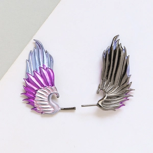 Close-up of gold-plated wing earrings with purple and blue gradient enamel details