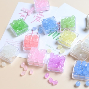 Vue macro de perles en résine macaron pastel en boîtes transparentes pour la création de bijoux