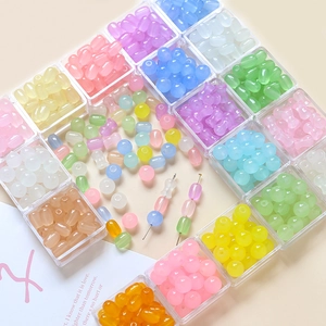 Vue détaillée de perles en verre macaron colorées dans une boîte de rangement pour bijoux DIY