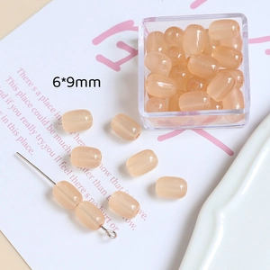 Détail de perles barils en résine abricot 6x9mm pour la création de bijoux et DIY