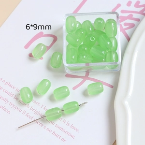 Vue détaillée de perles de verre baril translucides vertes 6x9mm avec trous droits