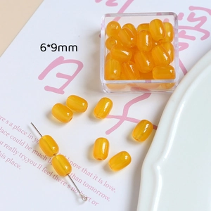 Détail macro de perles de résine ambre en forme de tonneau de 6x9mm pour bijoux DIY