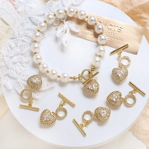 Macro shot of gold-plated heart-shaped OT toggles and pearl bracelet components