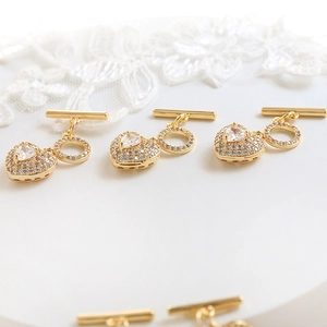Detail of heart-shaped OT toggles in gold plated finish with micro-pave cubic zirconia
