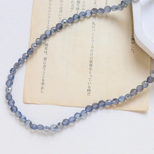 Gros plan de perles en verre de cristal facetté bleu-gris sur papier vintage