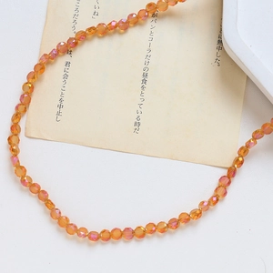 Gros plan de perles en cristal facetté orange avec reflet iridescent pour bijoux