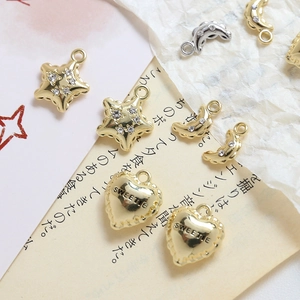 Macro detail of gold and silver heart, star, and moon charms with cubic zirconia for DIY