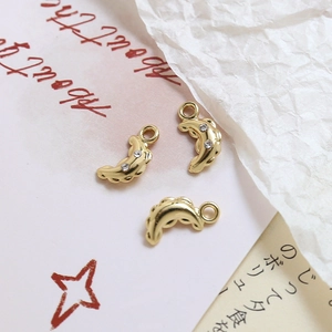 Macro shot of gold-plated crescent moon pendants with zircon stones for DIY jewelry making