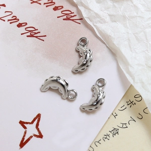Macro shot of silver crescent moon charms with sparkling zircon stones for DIY jewelry