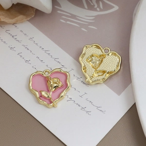 Detailansicht eines rosa Herzanhängers mit goldener Rose für DIY-Schmuckherstellung