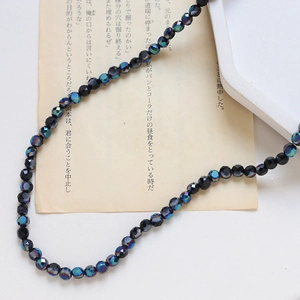 Gros plan de perles en cristal facetté aux reflets irisés métalliques sur papier vintage