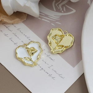 Details der Vintage-Herzanhänger mit goldener Rosenprägung und weißem Emaille-Finish