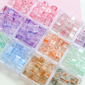 Colorful cube glass beads for DIY jewelry making in clear storage boxes with vertical texture