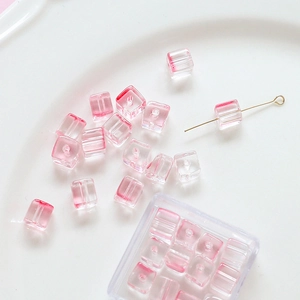 Macro shot of pink gradient glass cube beads with through-holes for DIY jewelry making