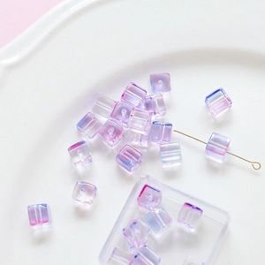 Macro shot of gradient blue and purple glass cube beads with gold jewelry pin