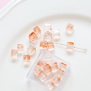 Macro detail of cube glass beads with orange gradient and hole for DIY jewelry making