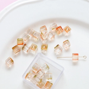 Detail of gradient glass cube beads in orange and green for DIY jewelry making