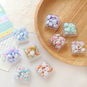 Detailed view of colorful gradient glazed flat round beads in clear storage boxes for DIY jewelry