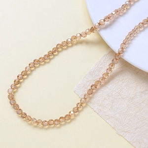 Dettaglio macro di perle di vetro cristallo sfaccettato champagne per gioielli fai da te
