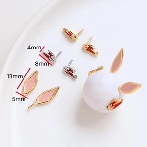 Detailed view of rabbit ear stud earrings in gold and red enamel with size measurements