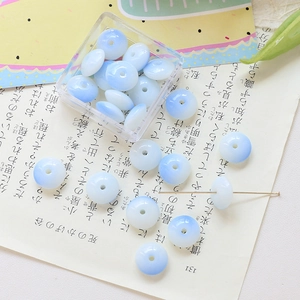 Macro shot of gradient blue and white glass flat round beads for DIY jewelry making