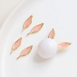 Detailed close-up of pink enamel rabbit ear charms for DIY handmade hair jewelry