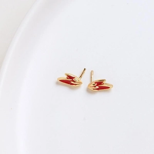 Detail shot of gold-plated rabbit ear hairpins with red enamel inlay on white plate
