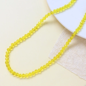 Dettaglio di perle in vetro di cristallo giallo brillante sfaccettate per gioielli fai da te