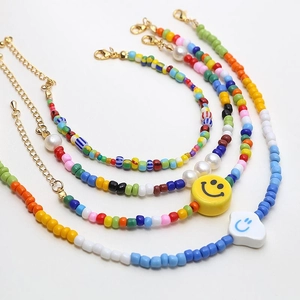 Detail of 4mm painted ceramic beads with smiley charms and golden lobster clasp