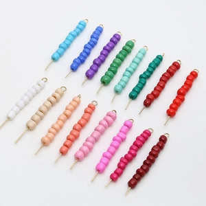 Close-up of 4mm colorful lacquered glass beads on gold pins for DIY jewelry making