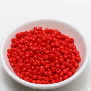 Detailed view of 4mm bright red seed beads in a white bowl for DIY jewelry making