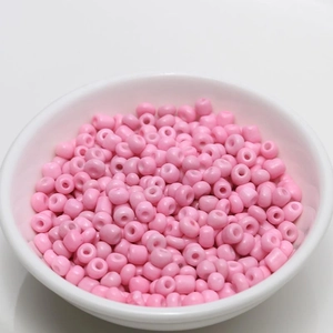 Macro view of 4mm pink lacquered porcelain beads in a white bowl for DIY jewelry making