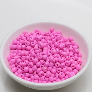 Macro view of 4mm pink seed beads for DIY jewelry making in a white bowl