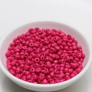 Macro detail of 4mm polished rose red round glass seed beads for DIY jewelry making