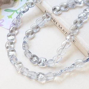 Close-up of light blue square glass beads with smooth texture for DIY jewelry making
