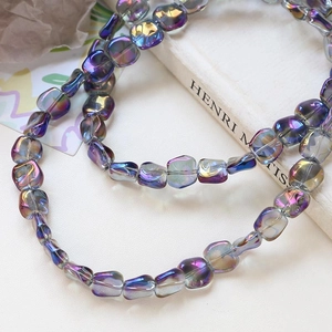 Macro detail of iridescent purple square glass beads with metallic aurora glaze finish