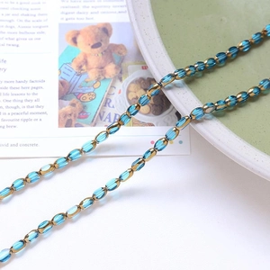 Detailed view of sky blue faceted crystal beads and golden metal spacers on a tray