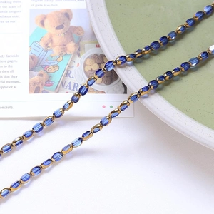 Detail of vintage blue faceted crystal beads and gold spacers on elegant card background