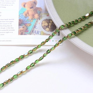 Macro detail of translucent green oval glass beads with gold spacers on a stylish magazine