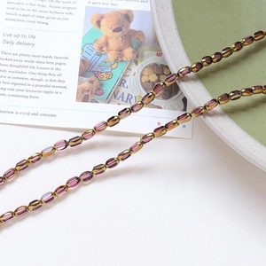 Detail of vintage purple crystal and gold beads for DIY jewelry making on a green plate