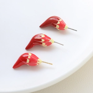 Macro shot of 18k gold-plated flame patterned DIY jewelry parts with red enamel finish